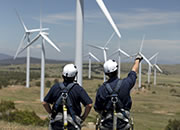 Two men standing near the windmills that provide wind energy